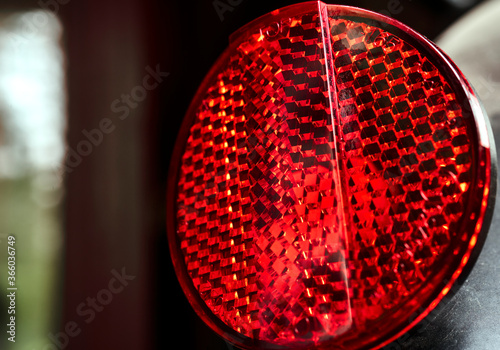 Round red reflector on a bicycle to increase road safety photo