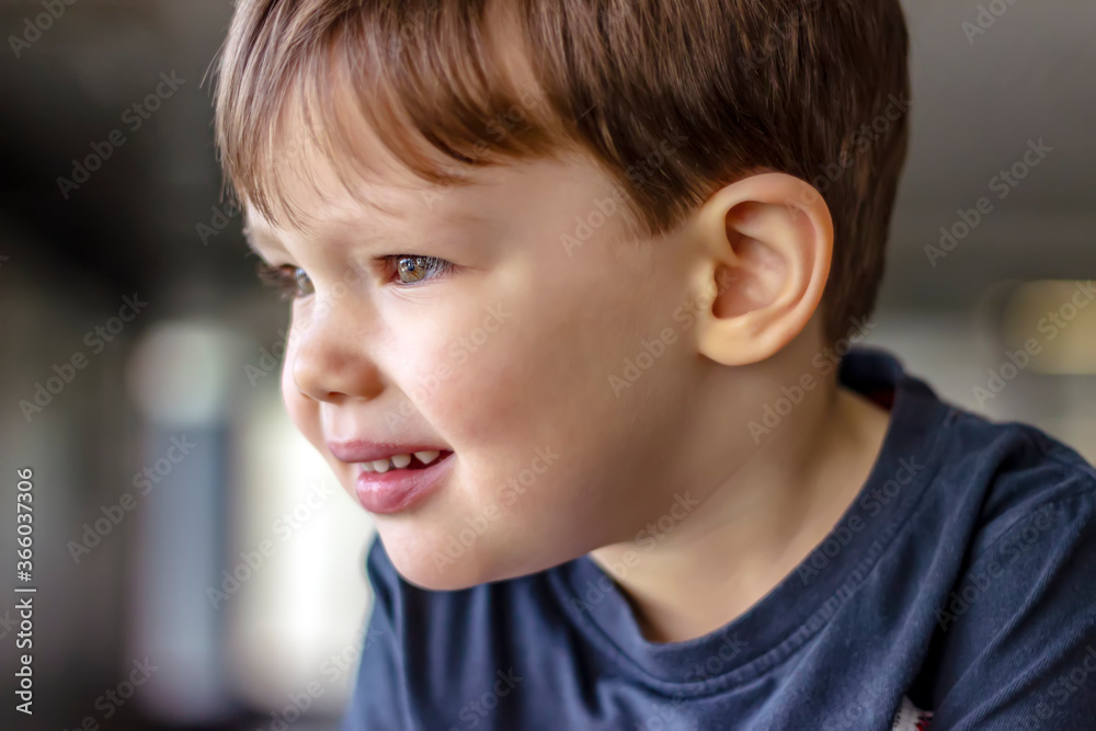 Cute boy profile outdoor portrait. The boy looking up with curious face. Portrait of boy deep in thoughts looking out the window. Cute boy profile outdoor portrait. The boy looking up with curious face. Portrait of boy deep in thoughts looking out the window.