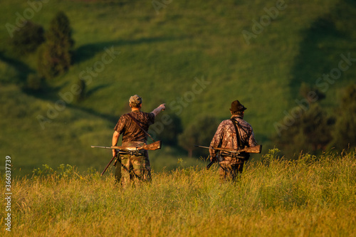 Two hunters going for an evening hunting in the mountains