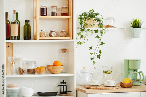 Background image of cozy kitchen interior with wooden shelves for spices and utencils decorated with plants, copy space © Seventyfour