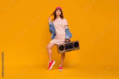 Full length body size view of nice attractive flirty cheerful girlish funny foxy ginger girl carrying boombox sending air kiss having fun isolated on bright vivid shine vibrant yellow color background