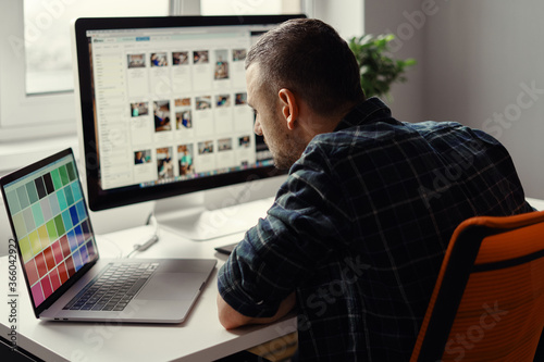 Handsome freelancer man working remotely from home. Young male working on his computer