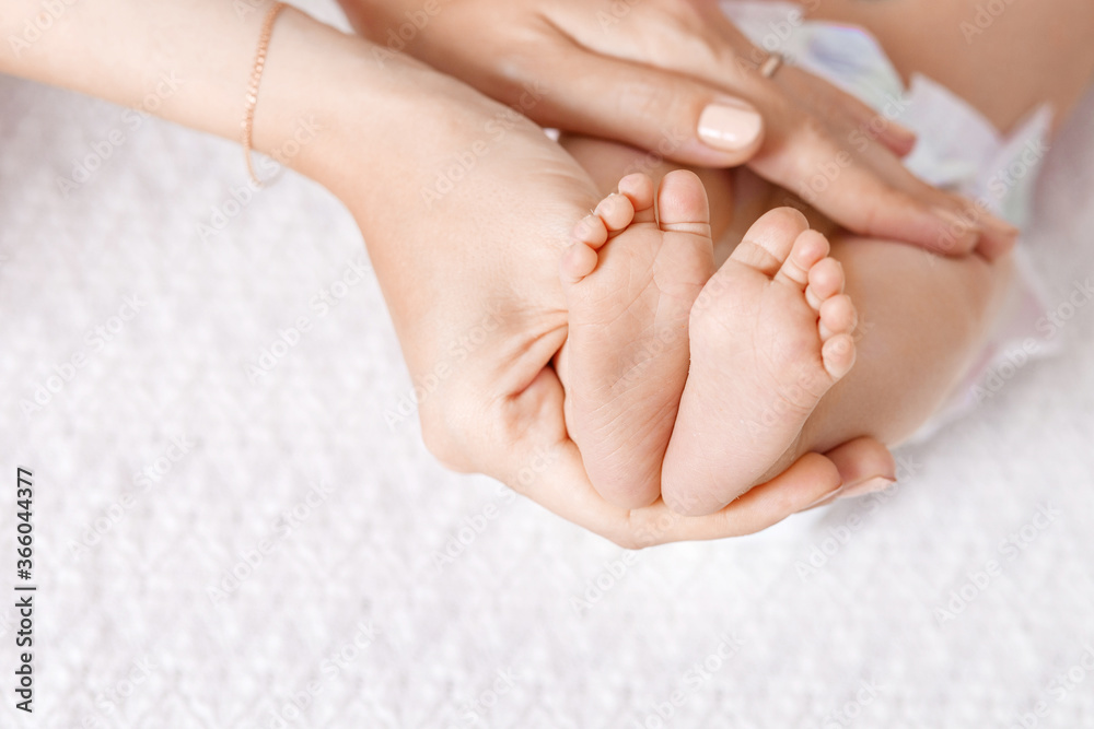 Parent holding in the hands feet of newborn baby.  Tiny newborn baby's feet on hands closeup. Mom and her child. Happy Family concept. Beautiful conceptual image of maternity. Copy space
