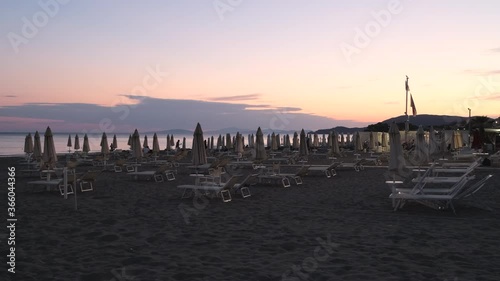 Beach umbrellas at sunset, watching the sea.