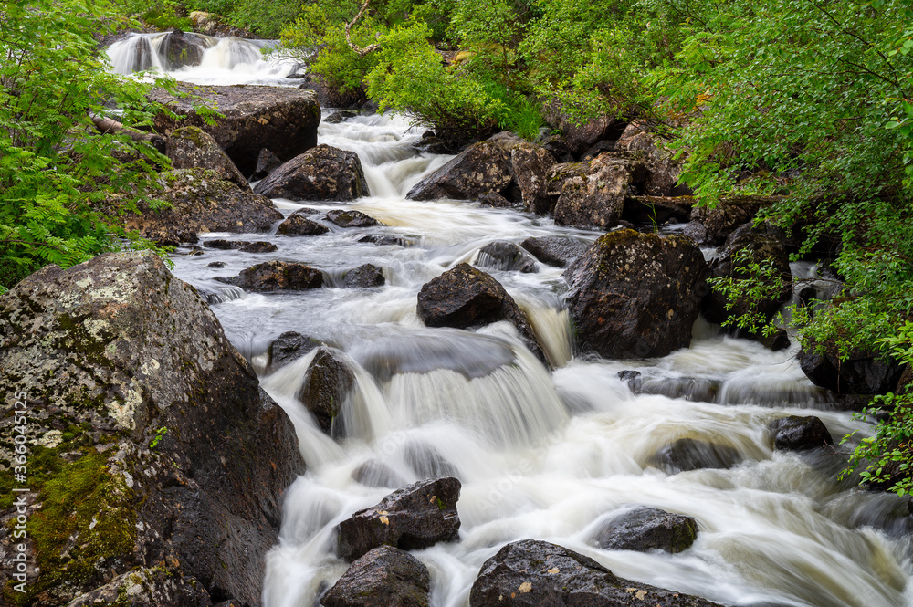 A beautiful scene of a small stream with white waters photographed in the Lapland wilderness. A beautiful scene of a small stream with white waters photographed in the Lapland wilderness.