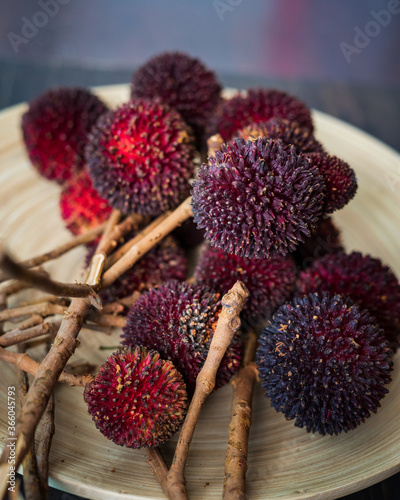 The exotic pulasan tropical fruit or scientific name Nephelium Mutabile on a wooden plate. Selective focus. photo