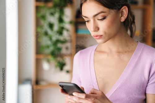 Woman designer indoors chatting by mobile phone