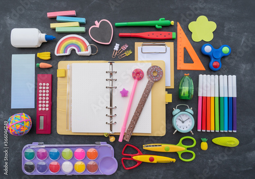 Stationery chalk board. Back to school. Open notepad on top of office supplies. Flat lay