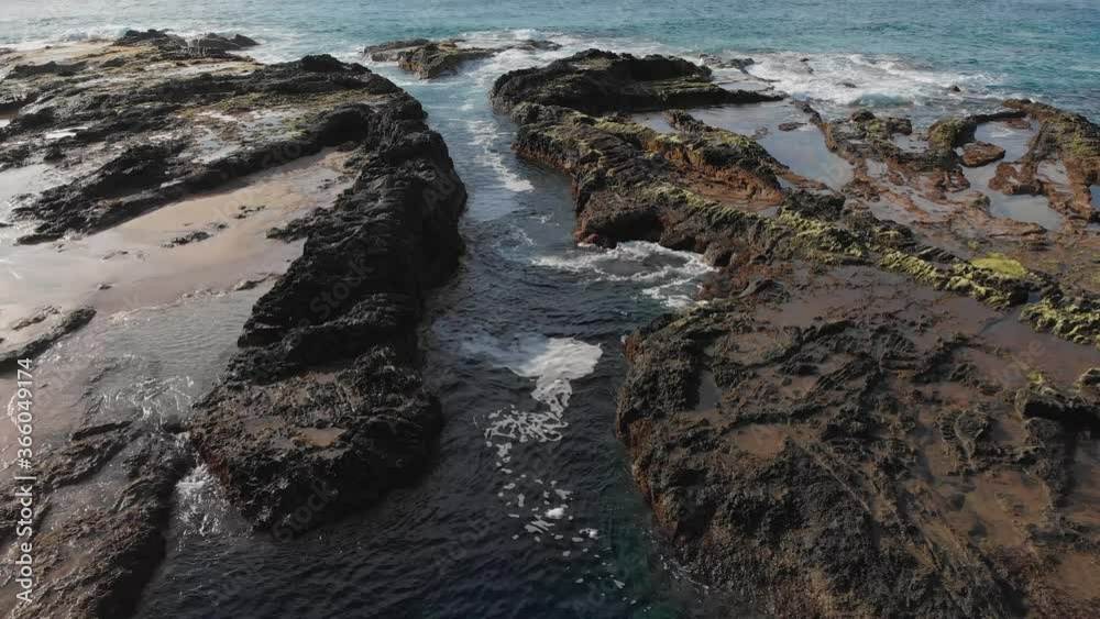 Slow tilt reveals the relaxing flow of the tide pools on the shore of Porto das Salemas Slow tilt reveals the relaxing flow of the tide pools on the shore of Porto das Salemas