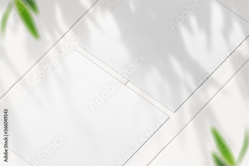 White Blank Square Flyers on white wooden desk closeup view
