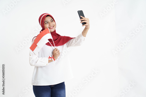 beautiful asian woman video calling using smartphone during independence day of indonesia