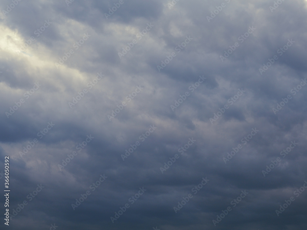 Dark gray heavy clouds in the sky before a thunderstorm. Dramatic gloomy background or wallpaper. Ahead of a storm or cataclysm. Climate and weather forecast backdrop