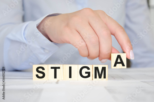 woman holds a cube with text. written text stigma