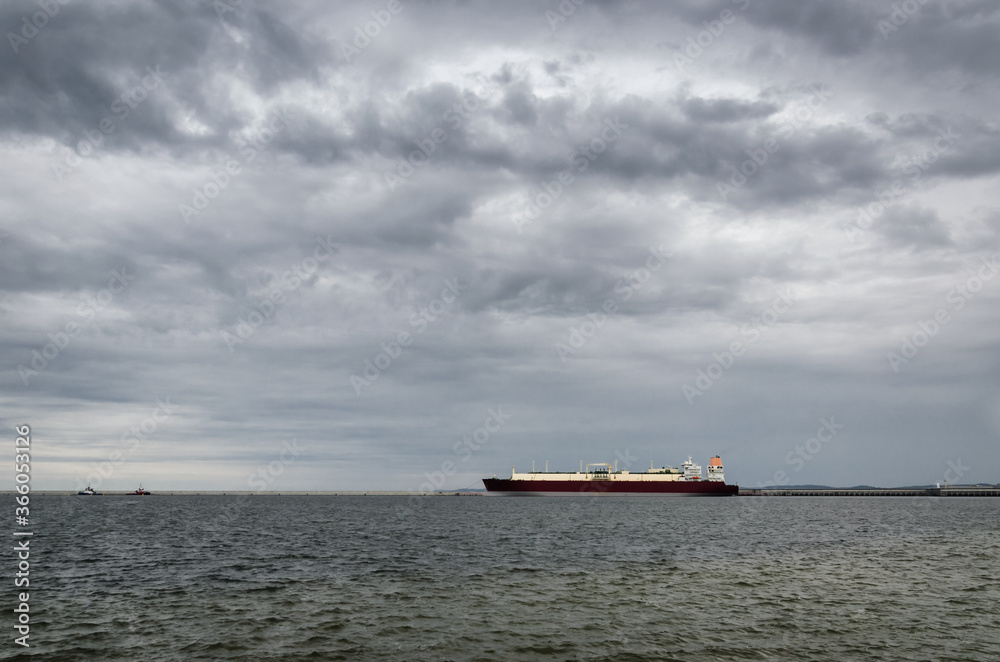 LNG TANKER IN SEAPORT - Rainy dramatic clouds on the ship and gas terminal
