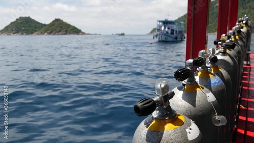 Tableau sur toile Row of oxygen tanks and diving equipment placed on modern boat in rippling ocean near Koh Tao resort, Thailand
