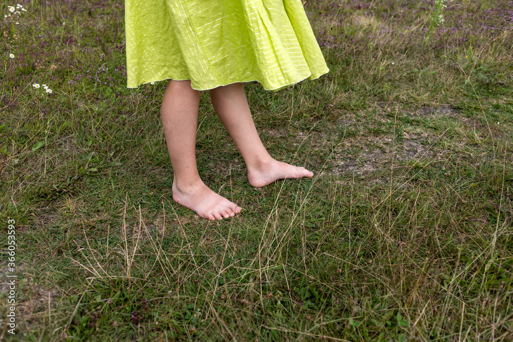 girl walking barefoot on the grass