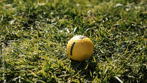 child puts a golf ball on the grass