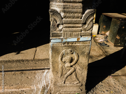 A carving of a figurine on a stone pillar of an ancient temple in Trichy photo