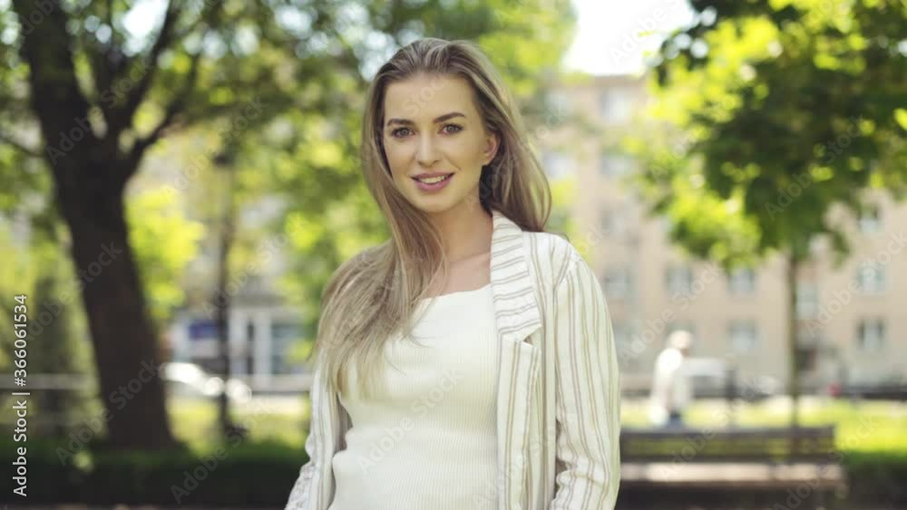 Portrait of beautiful young blonde woman in a city.