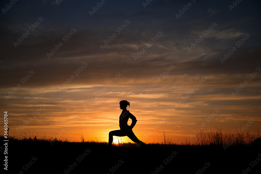 girl doing yoga in nature at sunset