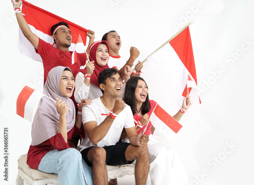 group of indonesian supporter celebrating victory together over white background. people holding flag during independence day of indonesia photo