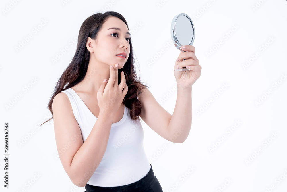 Portrait images of Asian young pretty woman is 25 years old, looking in the mirror Check the wrinkles around the lips, On white background, to beauty and cosmetic concept. Portrait images of Asian young pretty woman is 25 years old, looking in the mirror Check the wrinkles around the lips, On white background, to beauty and cosmetic concept.
