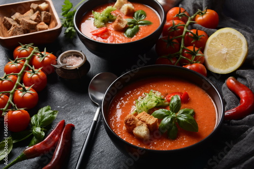 Andalusian gazpacho. Red tomato cold gazpacho soup in glass, with cucumber, onion, basil ,chili peppers and croutons.