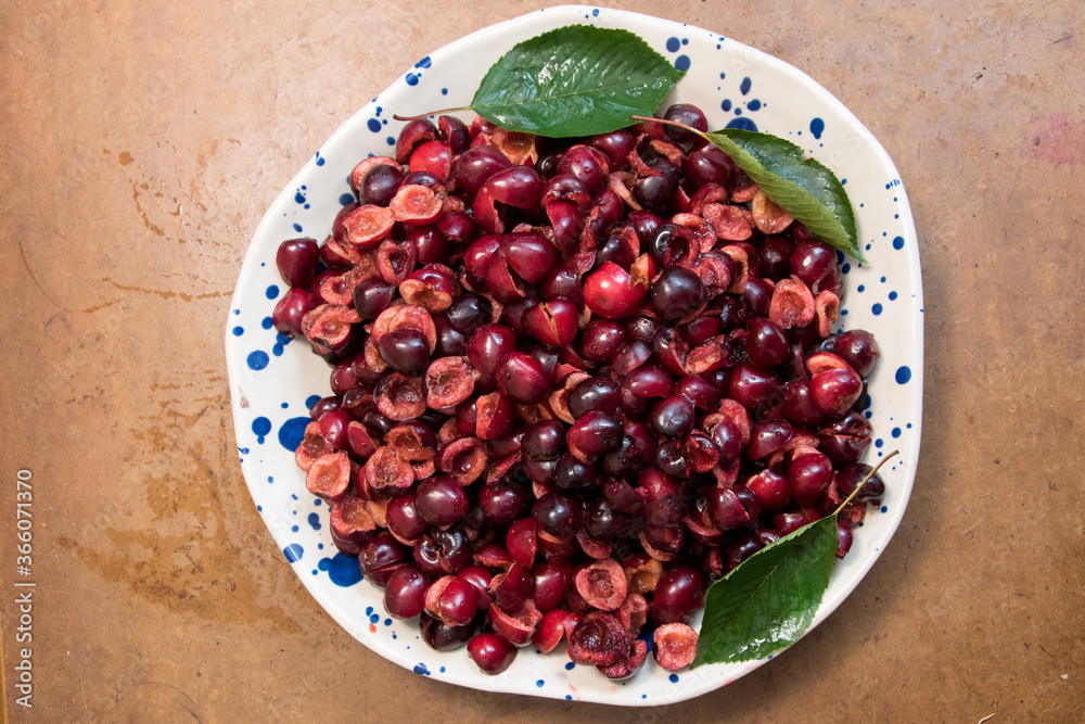 removing pits from cherries on a ceramic dish removing pits from cherries on a ceramic dish