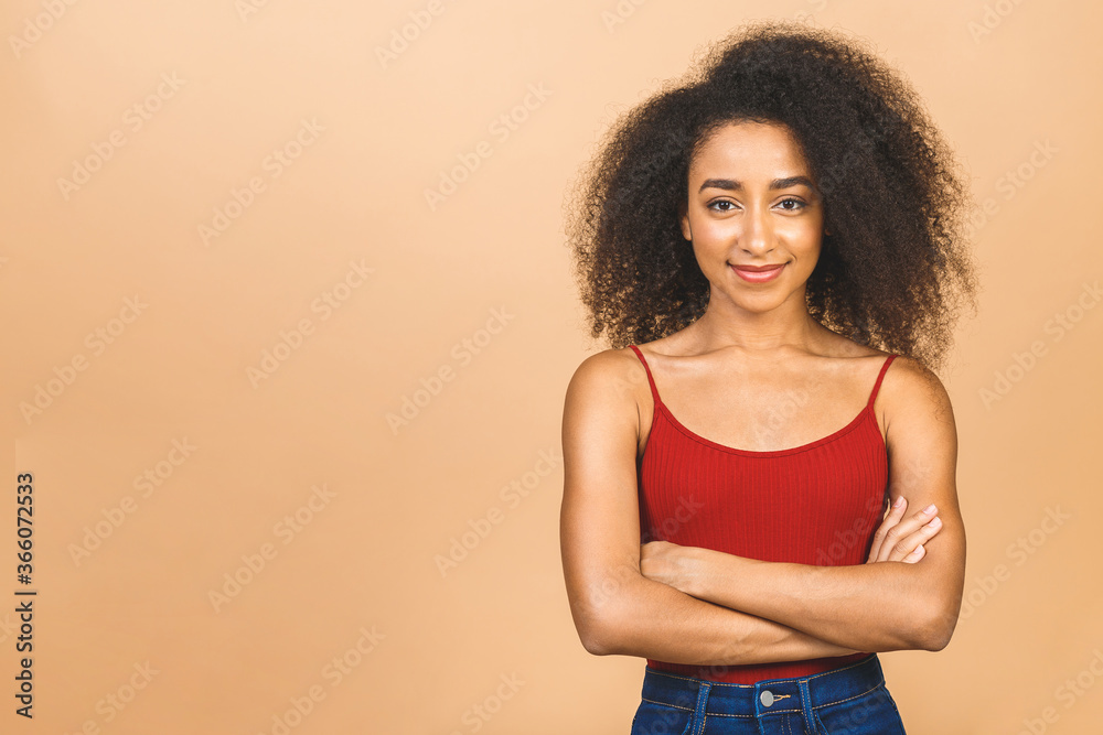 Portrait of beautiful positive african american black woman standing with arms crossed isolated over beige background. Portrait of beautiful positive african american black woman standing with arms crossed isolated over beige background.
