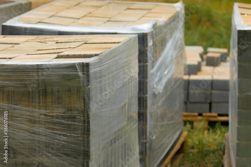 Packaging of new paving slabs. Cement tiles wrapped with stretch film for transportation. Selective focus. Construction Materials