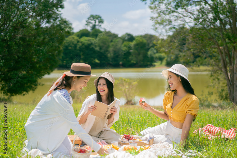 Asian woman friends, they are having picnic, eating in the morning, they talk happily. Asian woman friends, they are having picnic, eating in the morning, they talk happily.