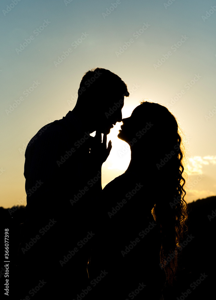 Marvelous silhouette of a loving couple on a background of evening sky, sunset