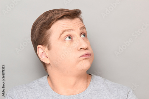 Photography Portrait of disappointed man sighing sadly, looking tired and bored
