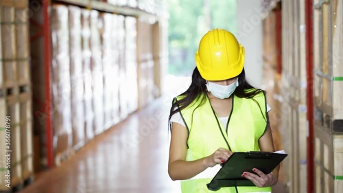 Worker wear face mask as new normal work check inventory in warehouse