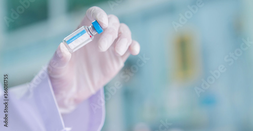 close up on scientist hand holding vaccine bottle for medical sample set at pharmaceutical operation room or scientific laboratory for fight and protect coronavirus (MERS-n COV) concept 