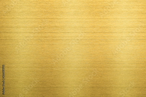 Gold metal texture of brushed stainless steel plate with the reflection of light.