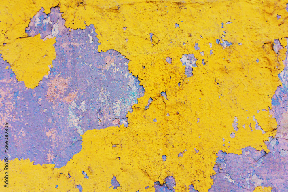 Texture of old, yellow paint on the wall.