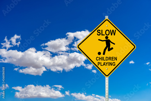 Slow Children Playing street sign with clouds and blue sky
