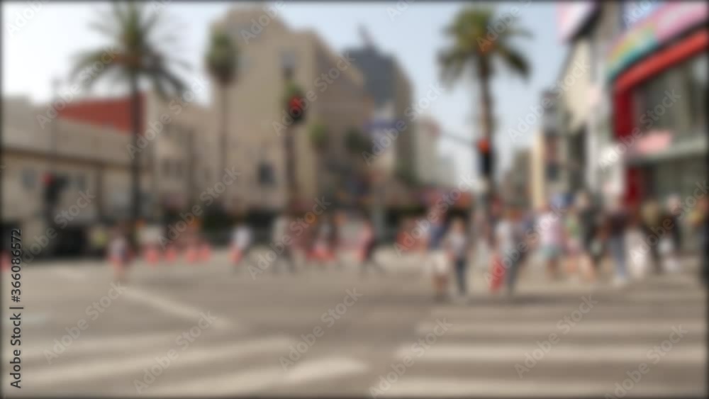 Walk of fame promenade, Los Angeles, Hollywood boulevard, California, USA. Pedastrians walking on on crossroad of streets. Entertainment and cinema industry iconic tourist landmark. Palms in LA city.