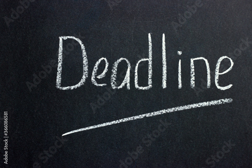  Inscription on a dark blackboard deadline with an underlined line. A common phrase among businessmen and freelancers
