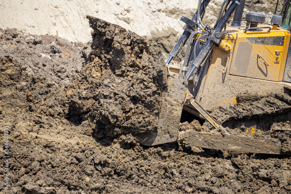 Heavy metal blades of Bulldozer move mounds of dirt Heavy metal blades of Bulldozer move mounds of dirt