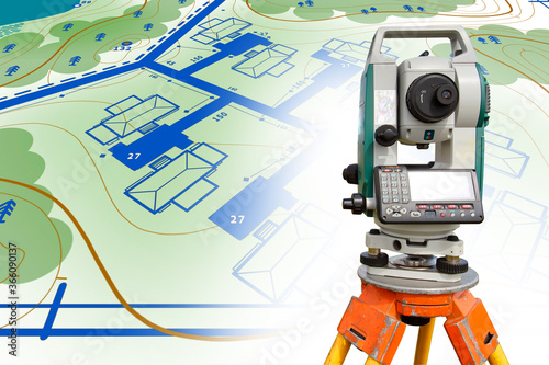 Total station close-up. Total station on the ground plan. Concept - provision of tapographic services. Total station is mounted on a tripod. Sale of equipment for tapography. Concept - cadastral work