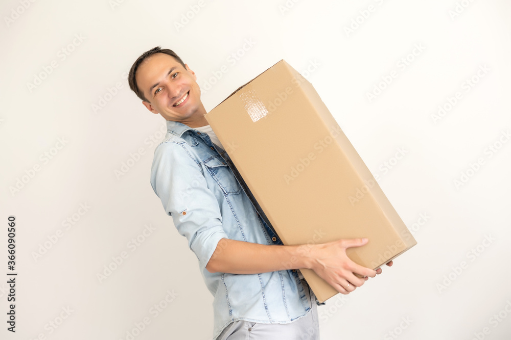 smiling delivery man holding a big parcel isolated on white