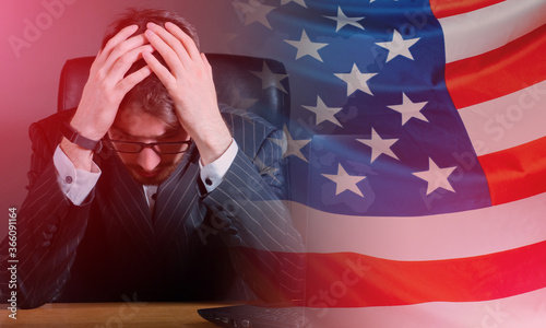 Wallpaper Mural Upset man next to USA flag. Guy is in depression. Man is sitting and holding on to his head. Concept - man is saddened by situation in America. Disorder happening in USA. Concept - bad news from USA. Torontodigital.ca