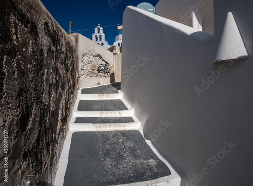 Streets and churches of the white city of Santorini under the bright sun. Greece. photo