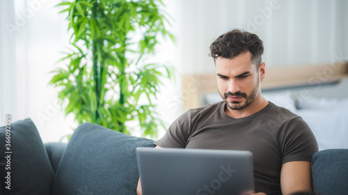 handsome man working from home with laptop, business freelancer concept