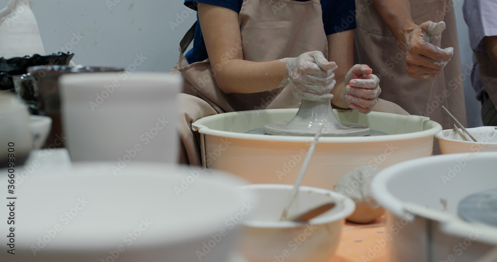 Hand work on pottery wheel, shaping a clay pot Hand work on pottery wheel, shaping a clay pot