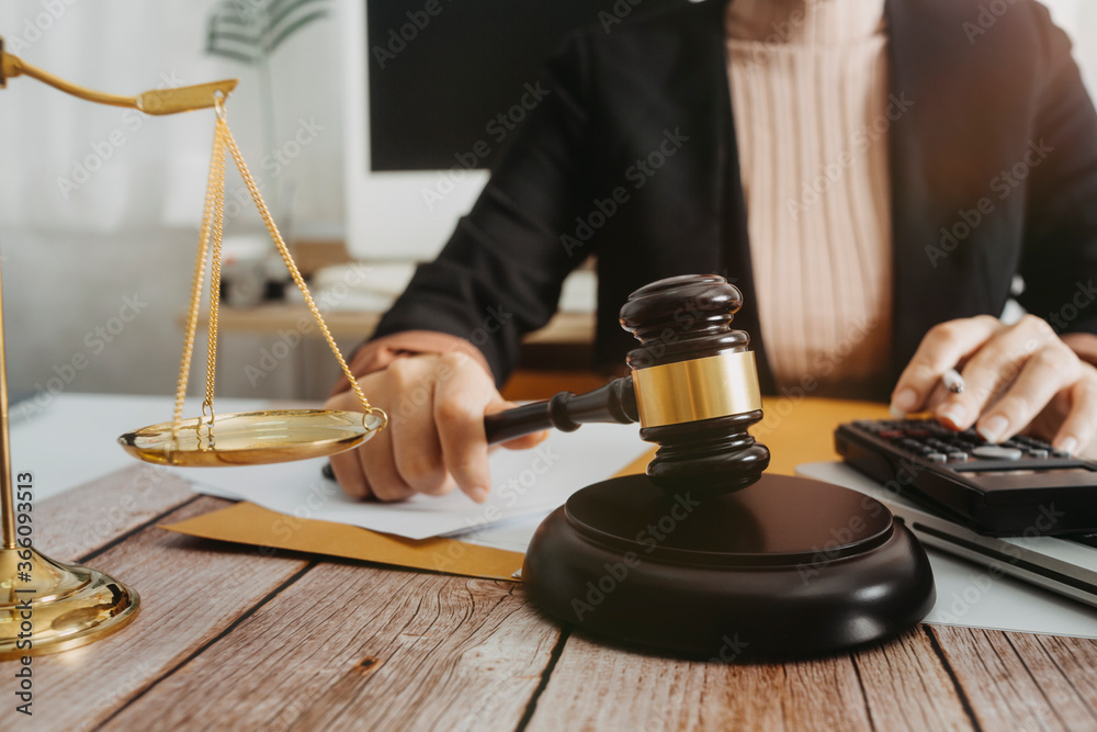 Business and lawyers discussing contract papers with brass scale on desk in office. Law, legal services, advice, justice and law concept picture with film grain effect Business and lawyers discussing contract papers with brass scale on desk in office. Law, legal services, advice, justice and law concept picture with film grain effect