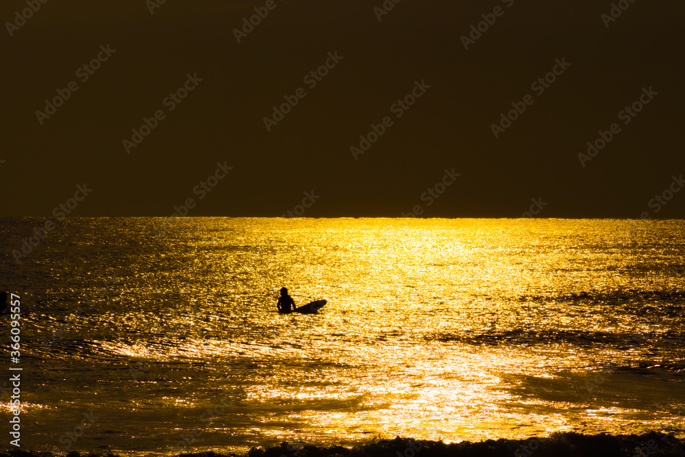 サーファーのシルエットと夕暮れの鎌倉海岸