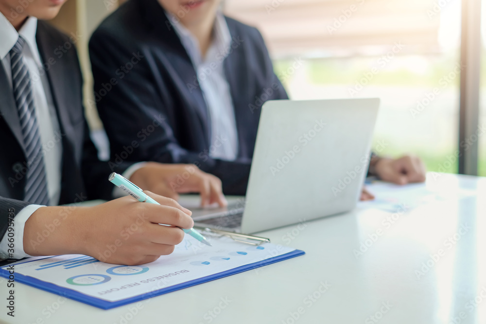 Working together of male businessmen, discuss the up and down graph of the economy. Working together of male businessmen, discuss the up and down graph of the economy.